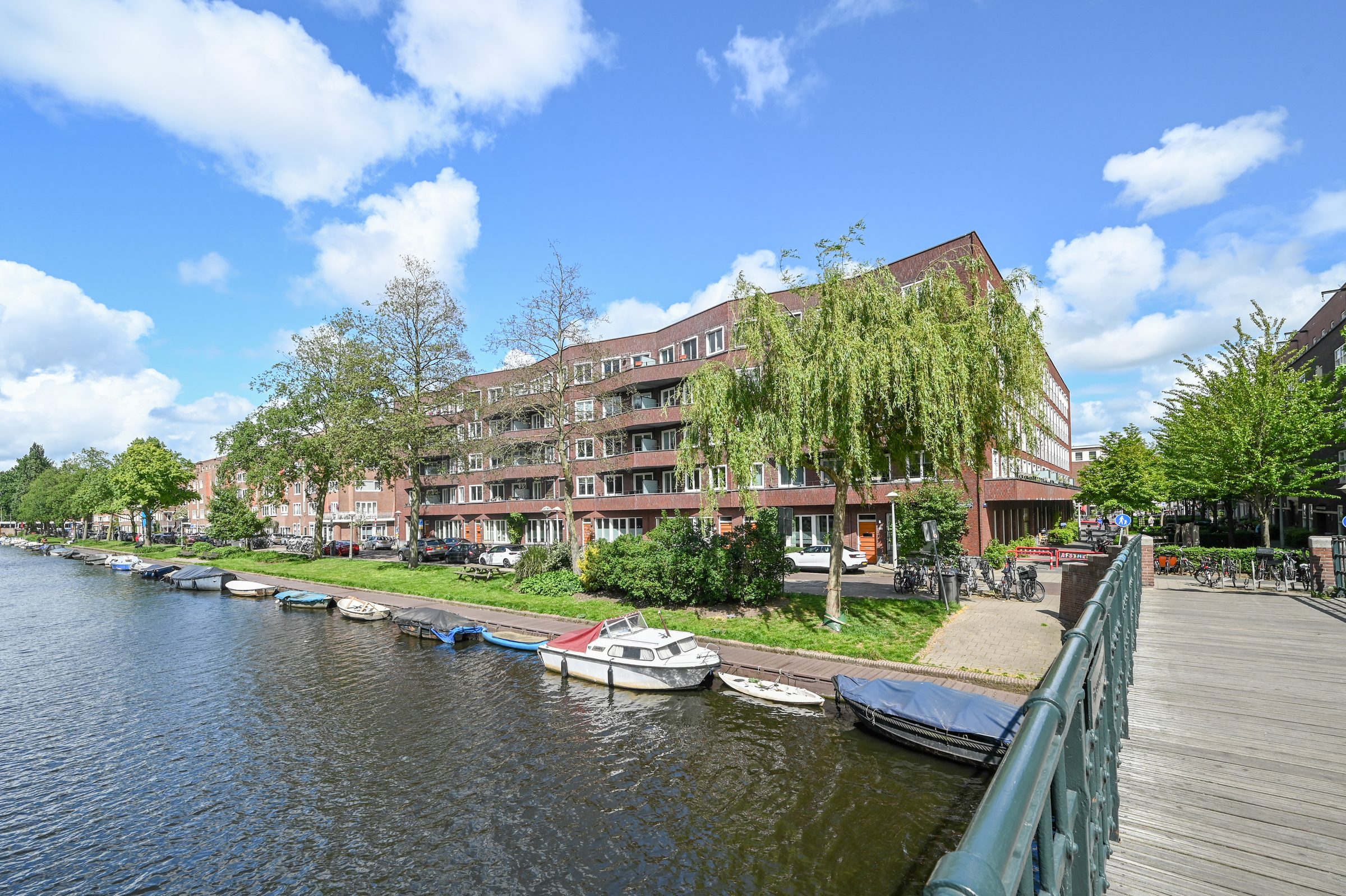Woonblok aan het water in Amsterdam-West met bomen en boten