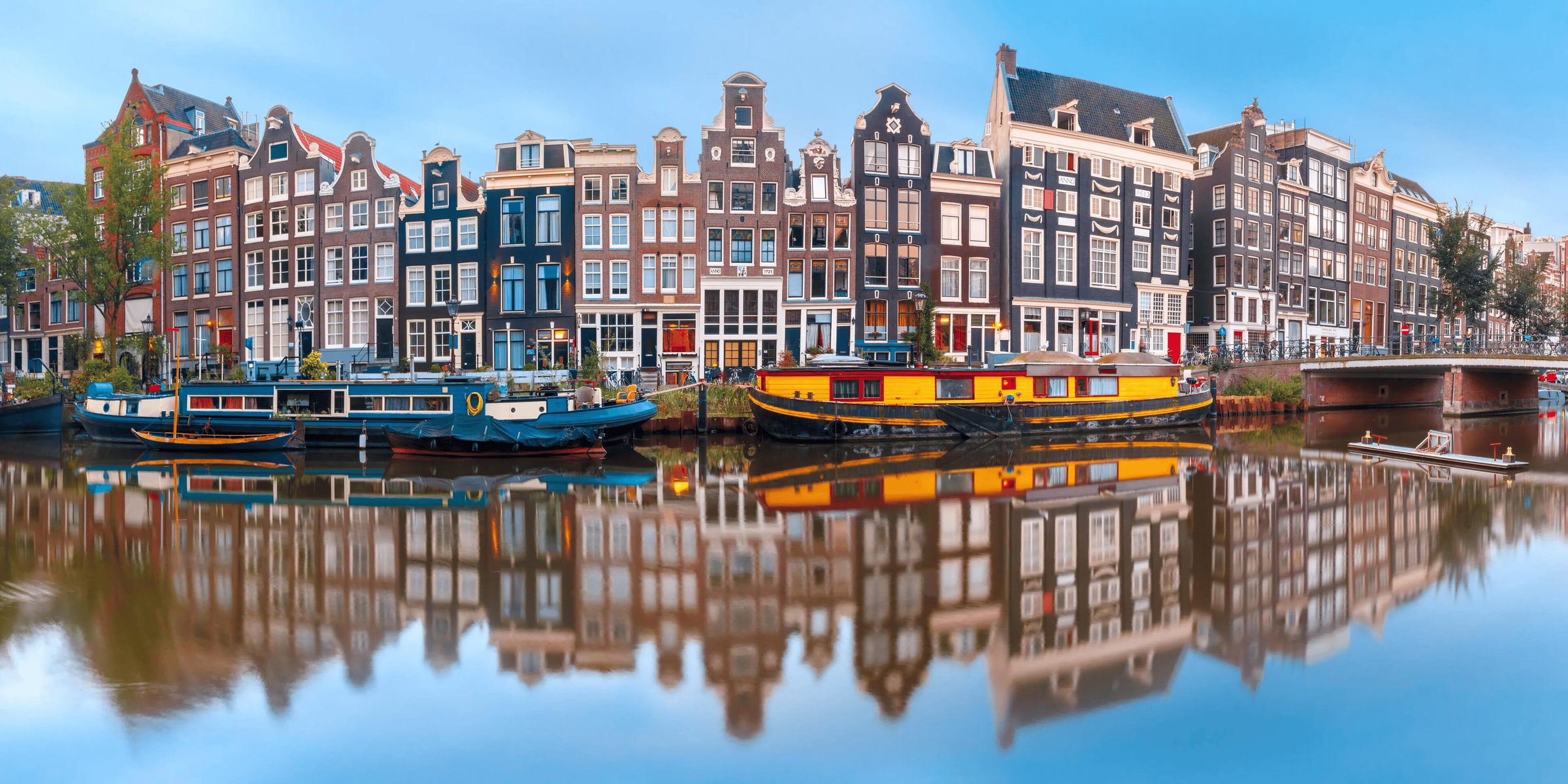 Rij grachtenpanden aan het Singel met woonboten, gespiegeld in het water