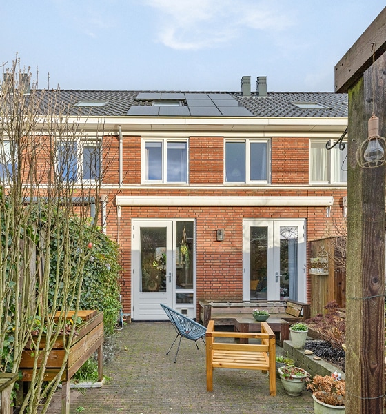 Achtertuin van tussenwoning met terras en zonnepanelen op het dak