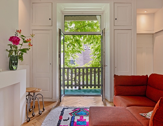 Bovenwoning in Amsterdam met openslaande deuren en balkon met groen uitzicht