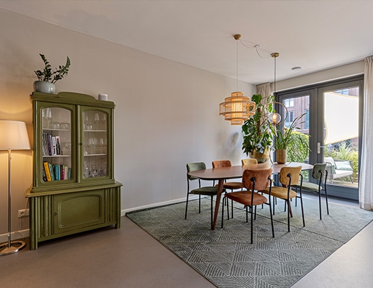 Lichte eetkamer in woning in Wormerveer met ronde eettafel en openslaande deuren naar balkon